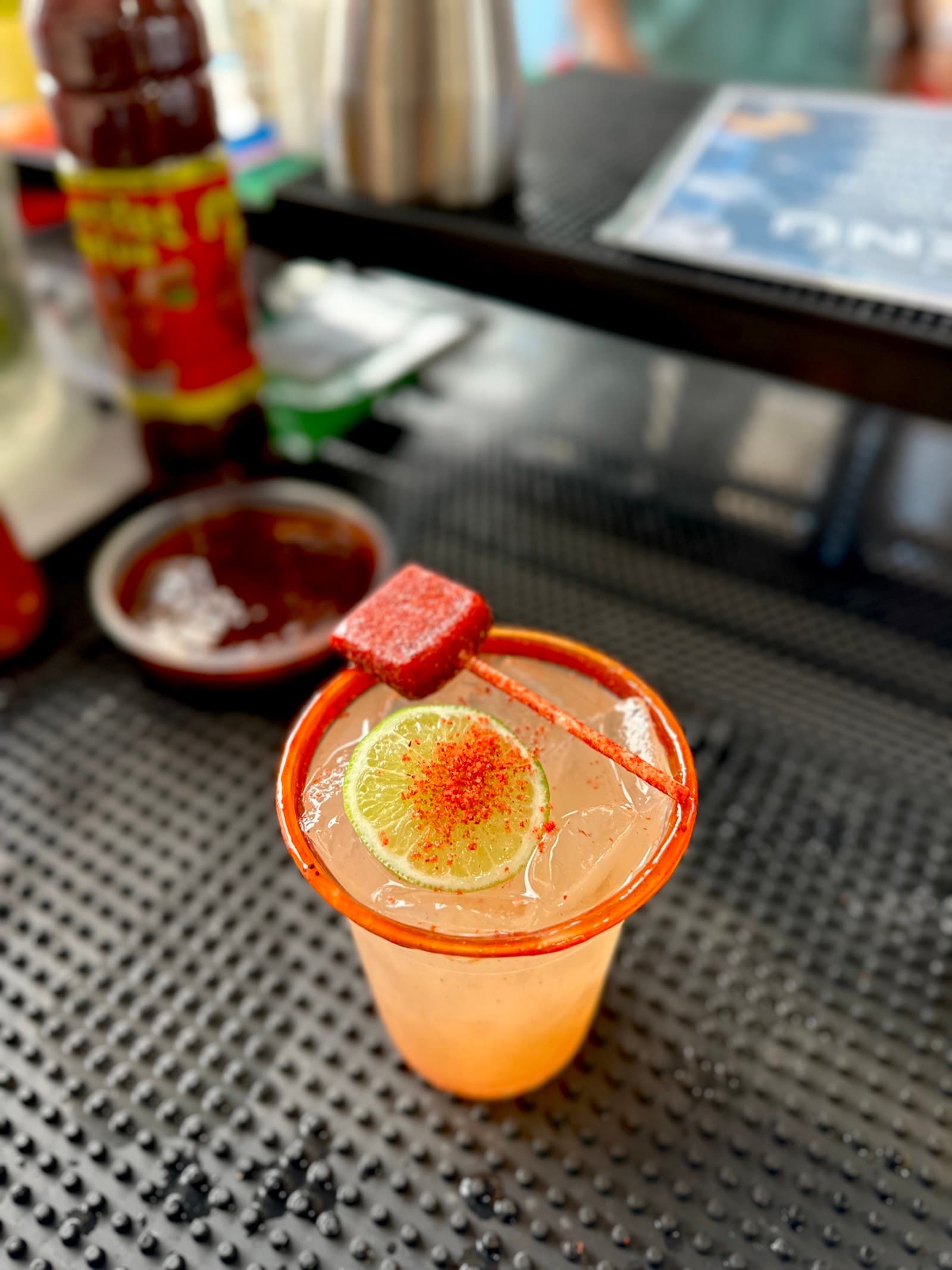 Chamoy-rim cocktail with tamarindo candy garnish
