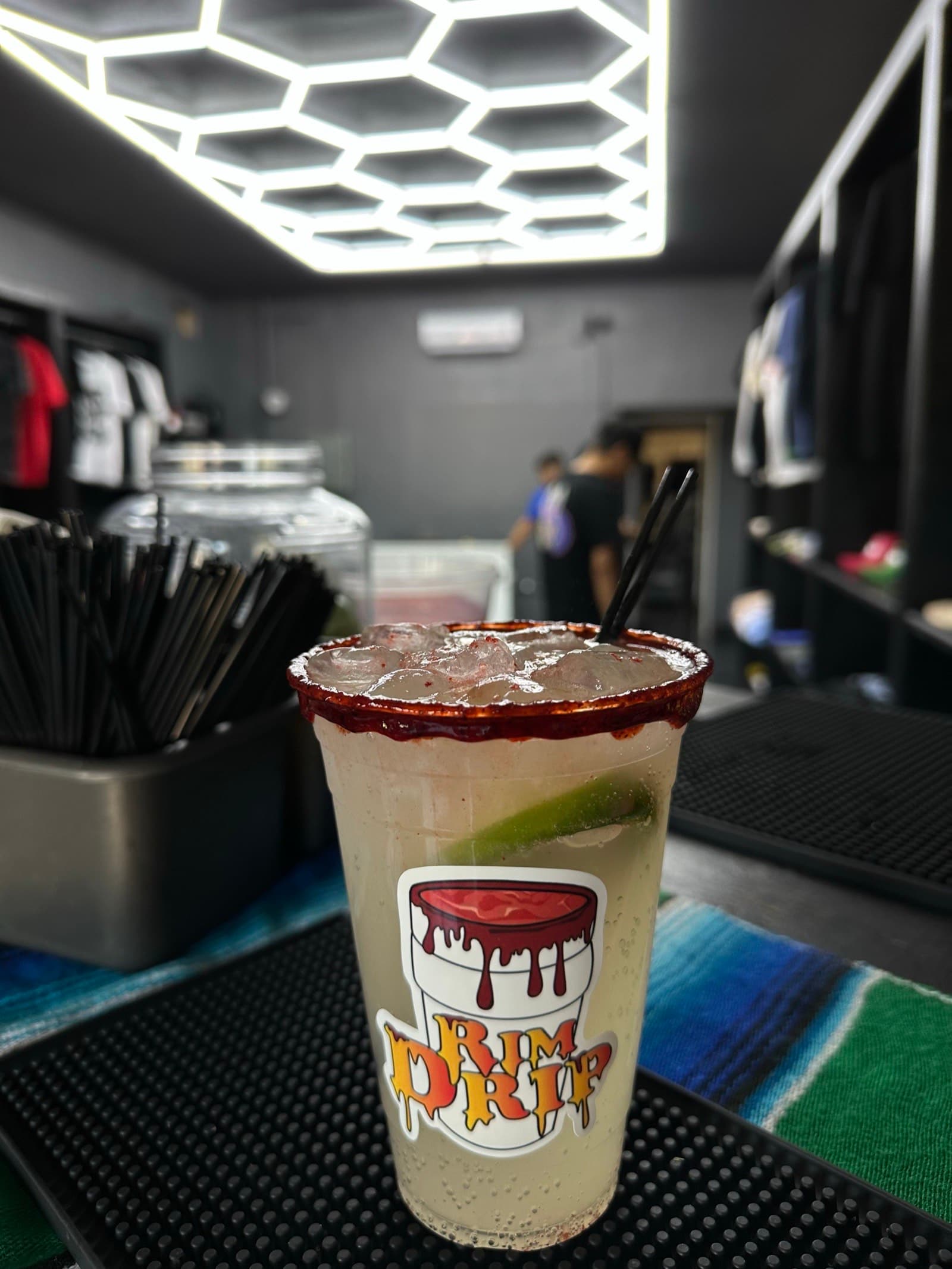 Chamoy-rim cocktail under a honeycomb lighting setup